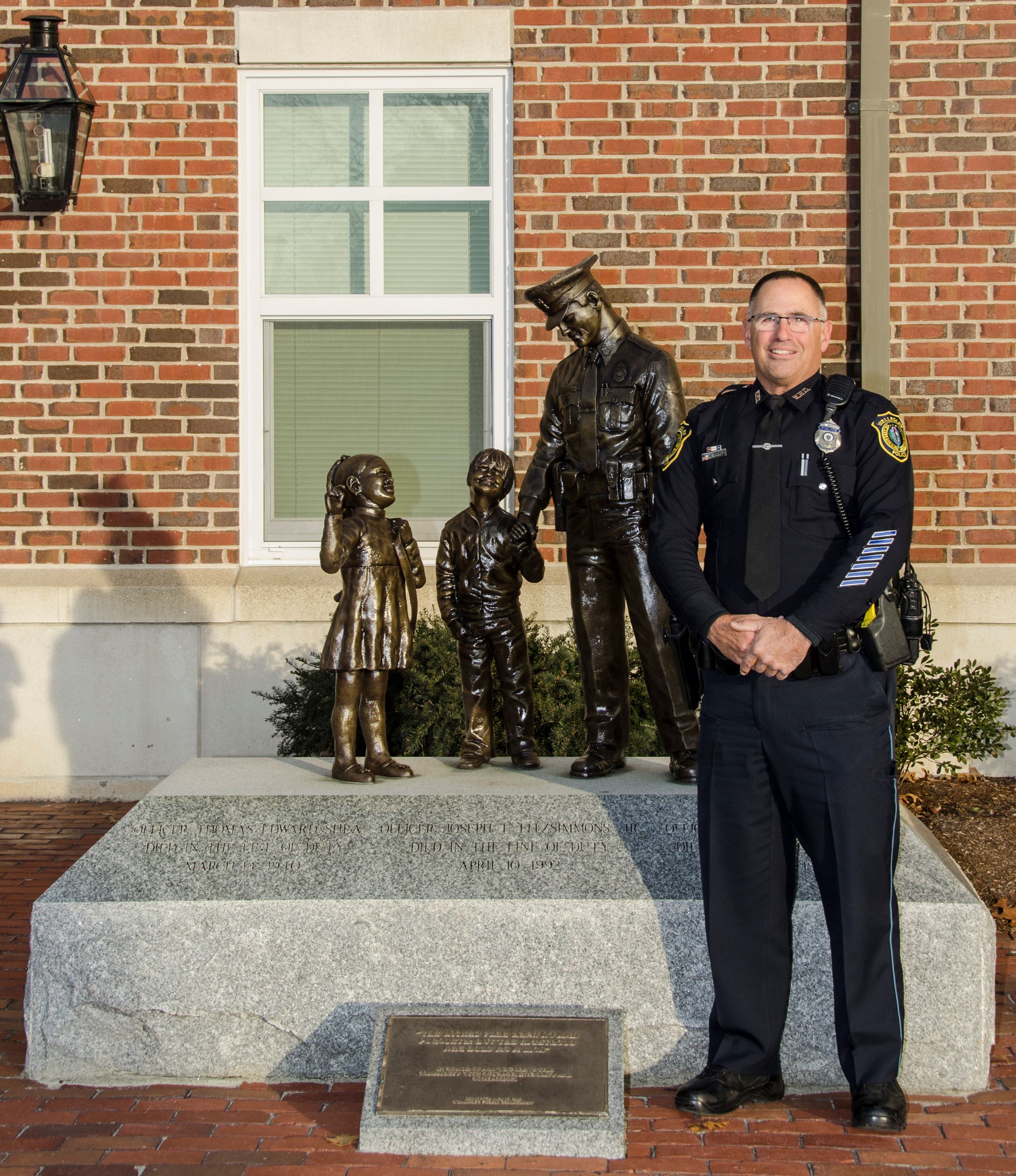 Officer Amalfi stands next to the WPD statute which bears his likeness on his last sunrise at Welles